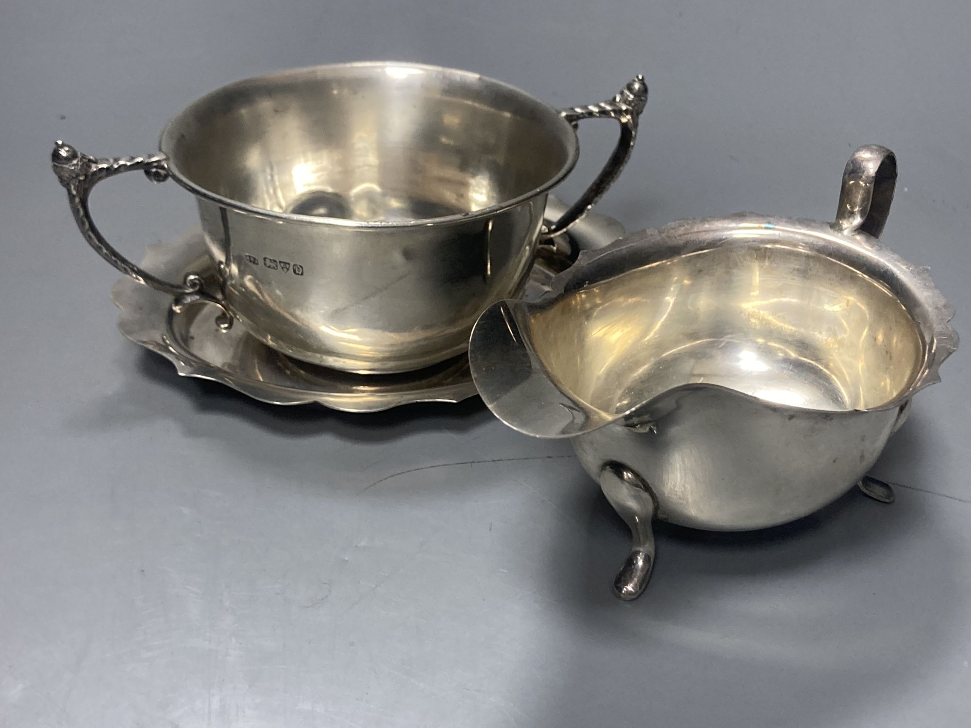 A late 19509s silver sauceboat on stand, Viners Ltd, Sheffield, 1958/9 and a George V silver porringer,